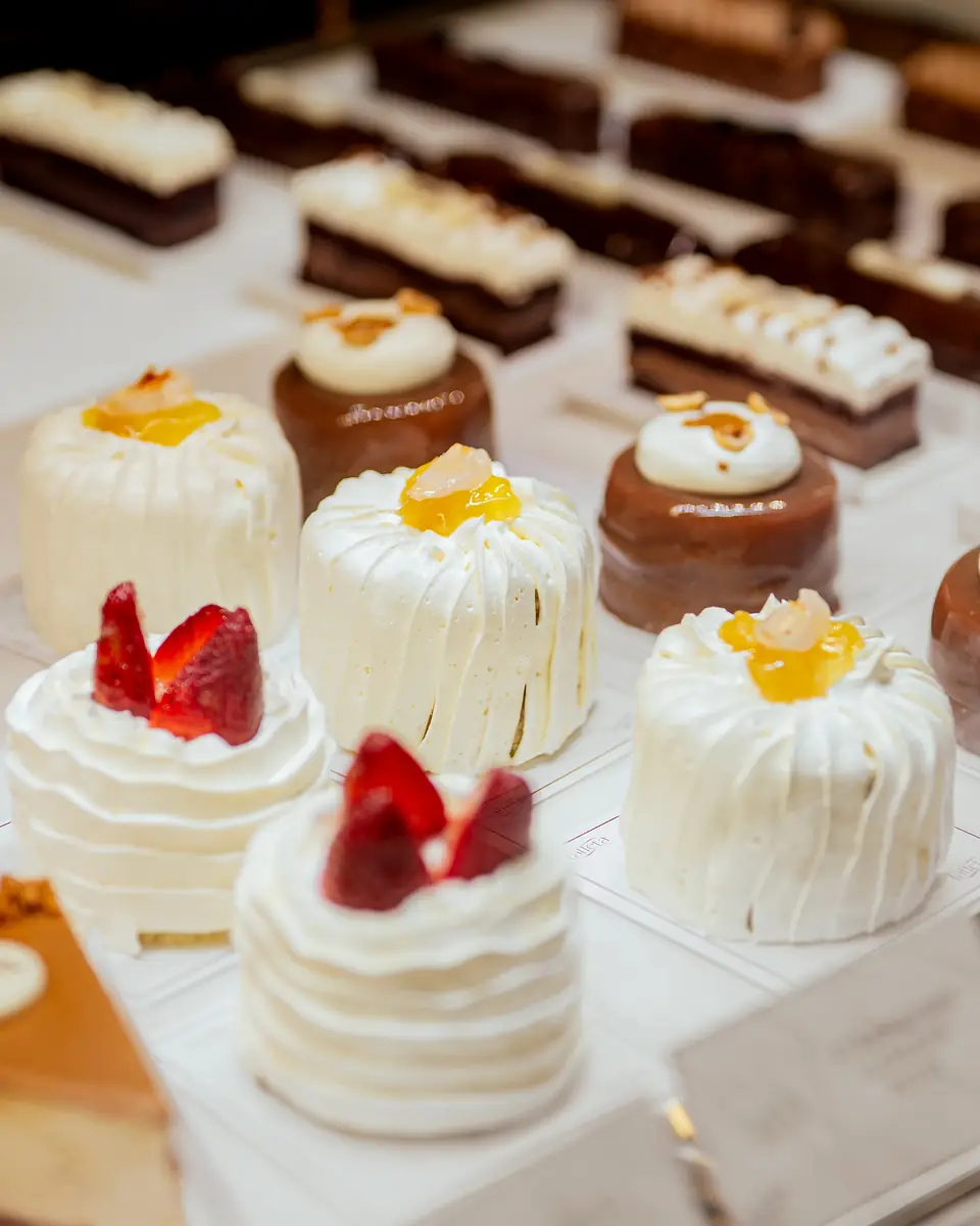 Rows of strawberry-topped cakes and chocolate bars in the dessert counter