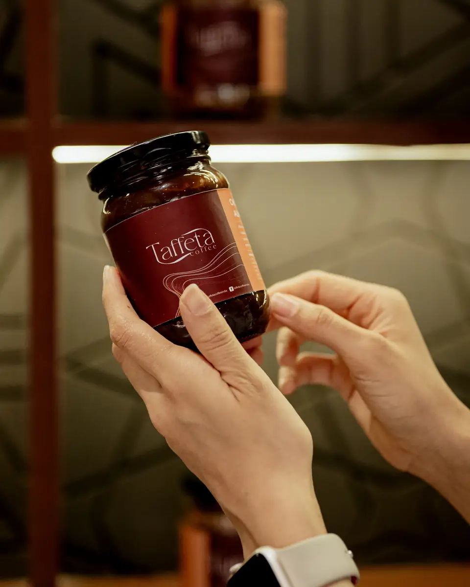 Close-up of a jar of whole Taffeta coffee beans with a burgundy label