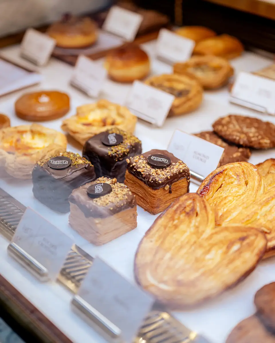 Puff pastries, tarts and glazed squares with name cards in the bakery display