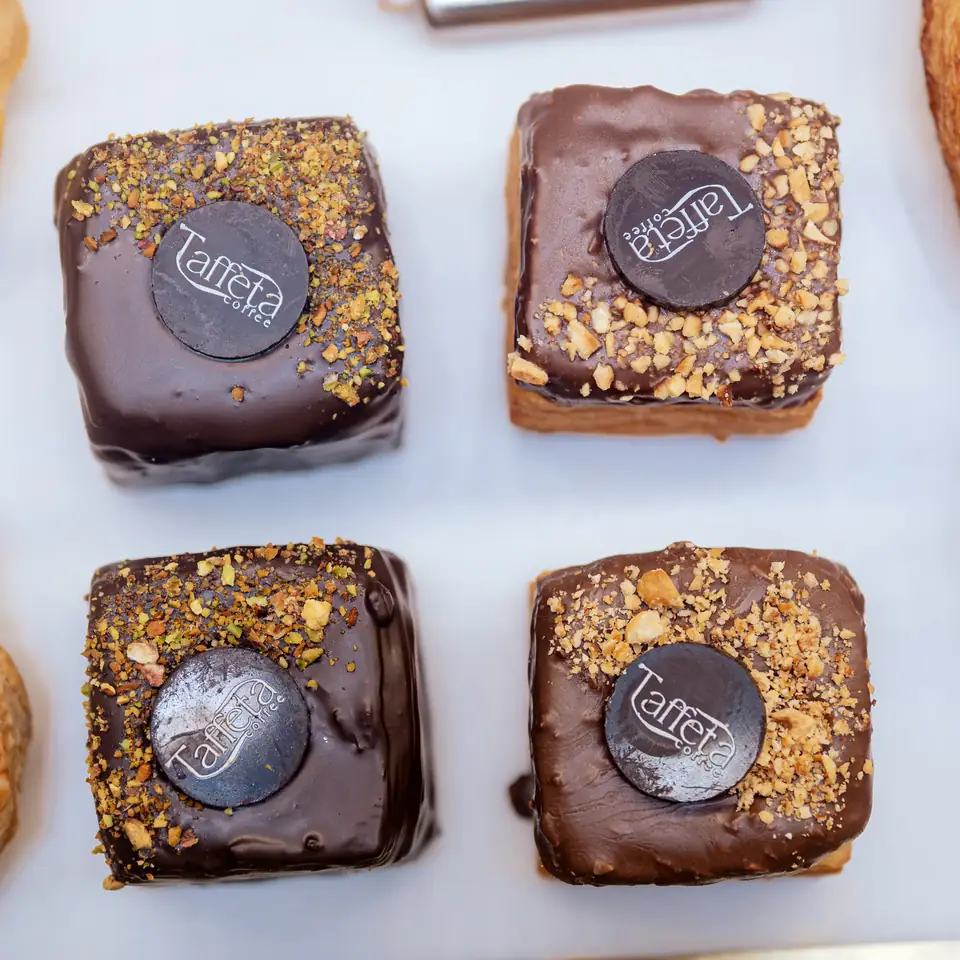 Four chocolate squares topped with a Taffeta chocolate disc, seen from above