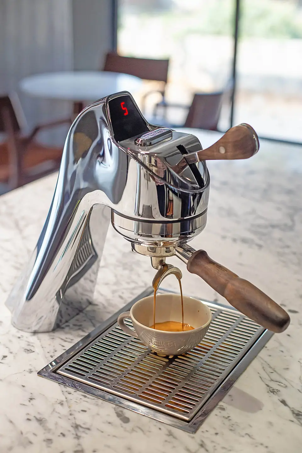 An espresso shot pouring from the Modbar into a small cup